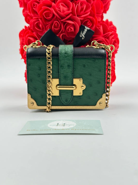 Prada Bandoliera 1BH058 struzzo verde smeraldo vista frontale, dettaglio hardware oro e fermaglio Prada, interno nappa nera logo Prada Made in Italy, scatola e card certificato autenticità Prada originale