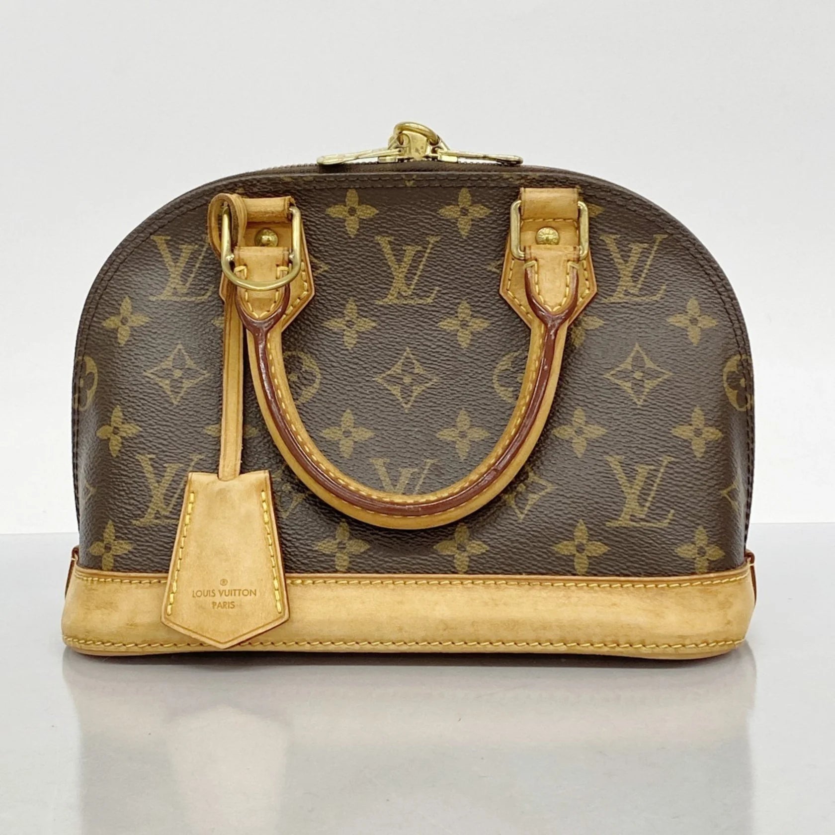 Borsa Louis Vuitton Alma BB Monogram marrone con tracolla, clochette e lucchetto.